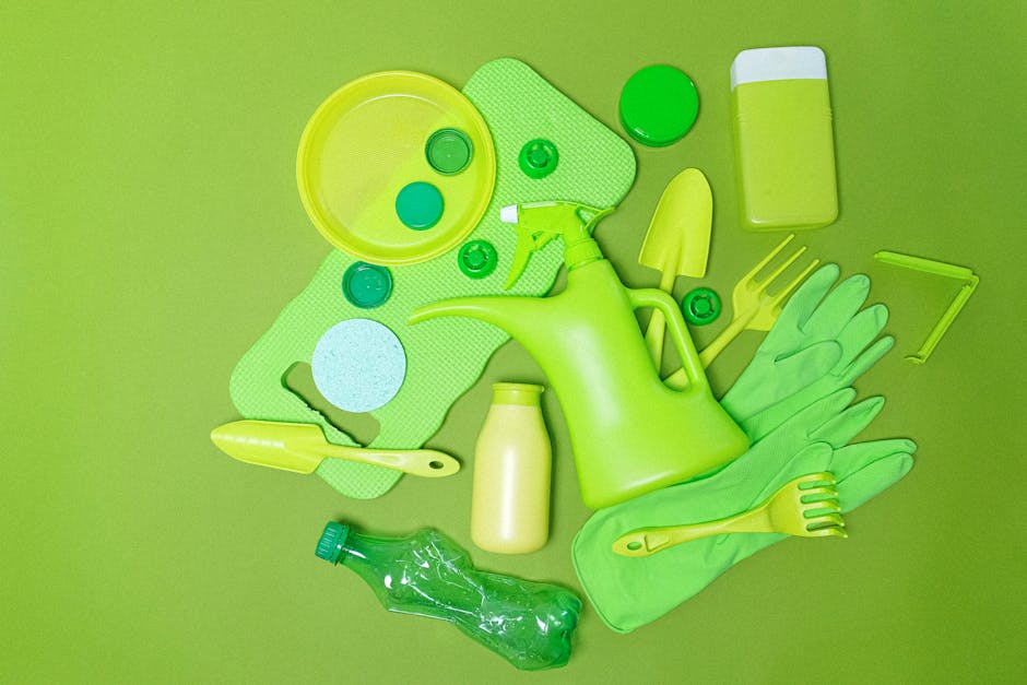 A collection of green gardening tools and supplies arranged on a vibrant lime green background, including a watering can, rubber gloves, a small trowel, a rake, a spray bottle, a plastic water bottle,